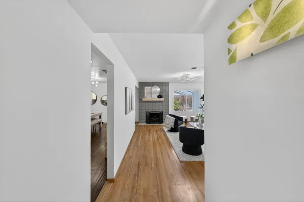 a hallway with a view of living room with wooden floor