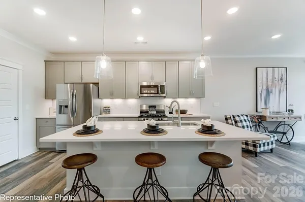 a kitchen with granite countertop a table and chairs in it