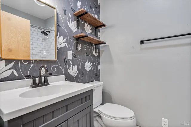 a bathroom with a sink a toilet and mirror