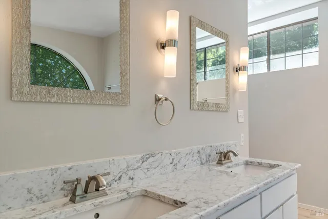 a bathroom with a granite countertop sink a mirror and a window