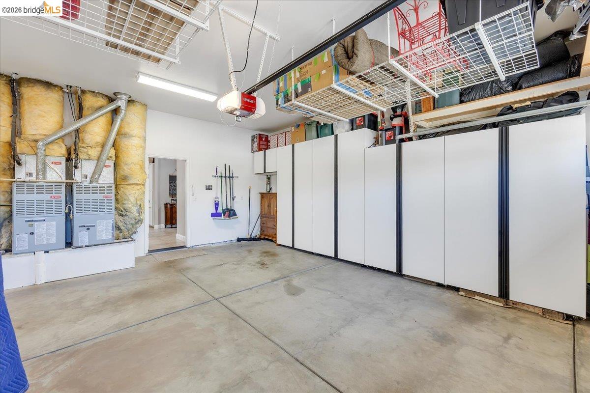 158 Rock Ridge Lane Copperopolis, CA 95228 - Photo 45 of 72 Spacious garage featuring concrete flooring, extensive built-in cabinetry, overhead storage racks, and fluorescent lighting