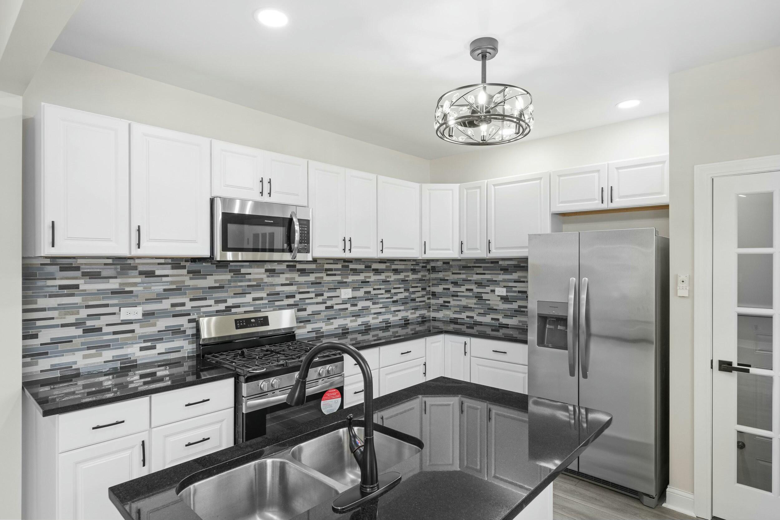800 Garfield Street Gary, IN 46404 - Photo 12 of 23 a kitchen with stainless steel appliances granite countertop a sink stove and refrigerator