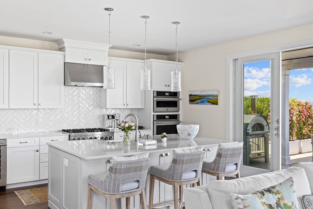 148 Hatherly Road, Unit 148 Scituate, MA 02066 - Photo 12 of 42 a kitchen with stainless steel appliances kitchen island granite countertop a table chairs and a refrigerator