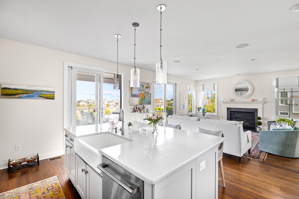 148 Hatherly Road, Unit 148 Scituate, MA 02066 - Photo 13 of 42 a kitchen with stainless steel appliances kitchen island granite countertop a sink a stove and a wooden floors