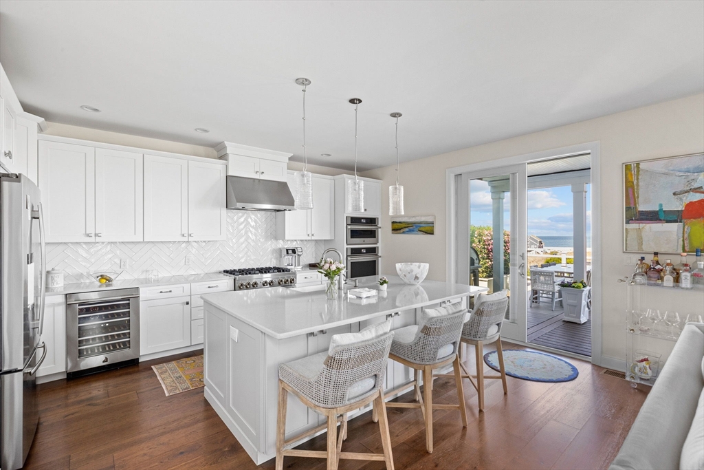 148 Hatherly Road, Unit 148 Scituate, MA 02066 - Photo 10 of 42 a kitchen with stainless steel appliances granite countertop a stove top oven a sink dishwasher a dining table and chairs with wooden floor