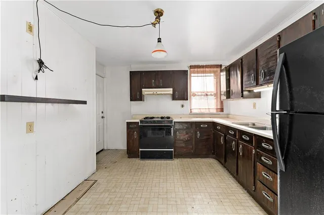 a kitchen with stainless steel appliances granite countertop a refrigerator a sink dishwasher a stove with wooden floor