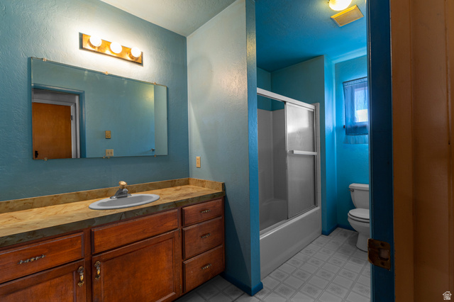 1208 East Tidwell Road Loa, UT 84747 - Photo 23 of 40 Bathroom with vanity, combined bath / shower with glass door, a textured wall, and light flooring