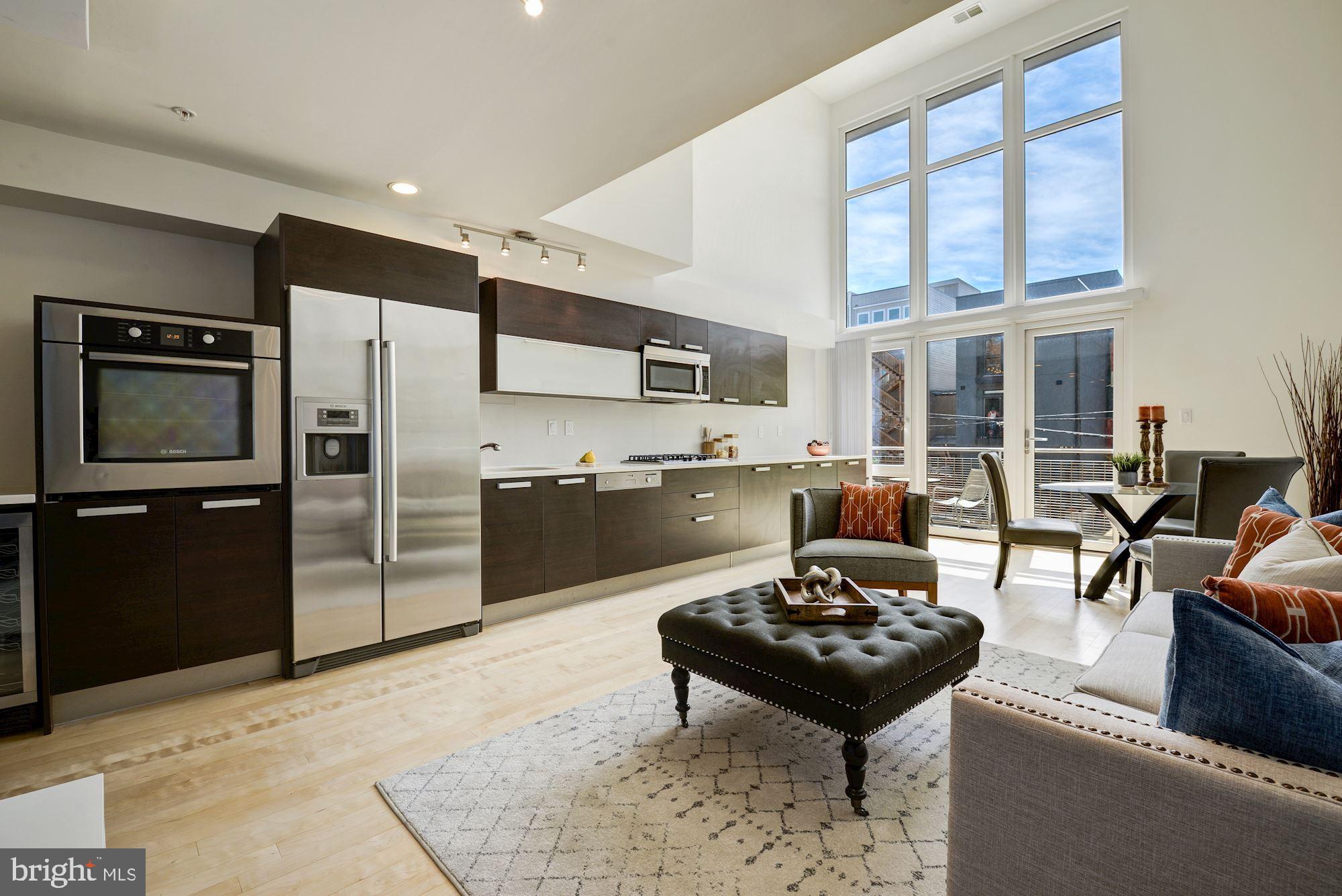 1466 Harvard Street Northwest, Unit A2 Washington, DC 20009 - Photo 2 of 21 a living room with stainless steel appliances furniture a rug and a kitchen view