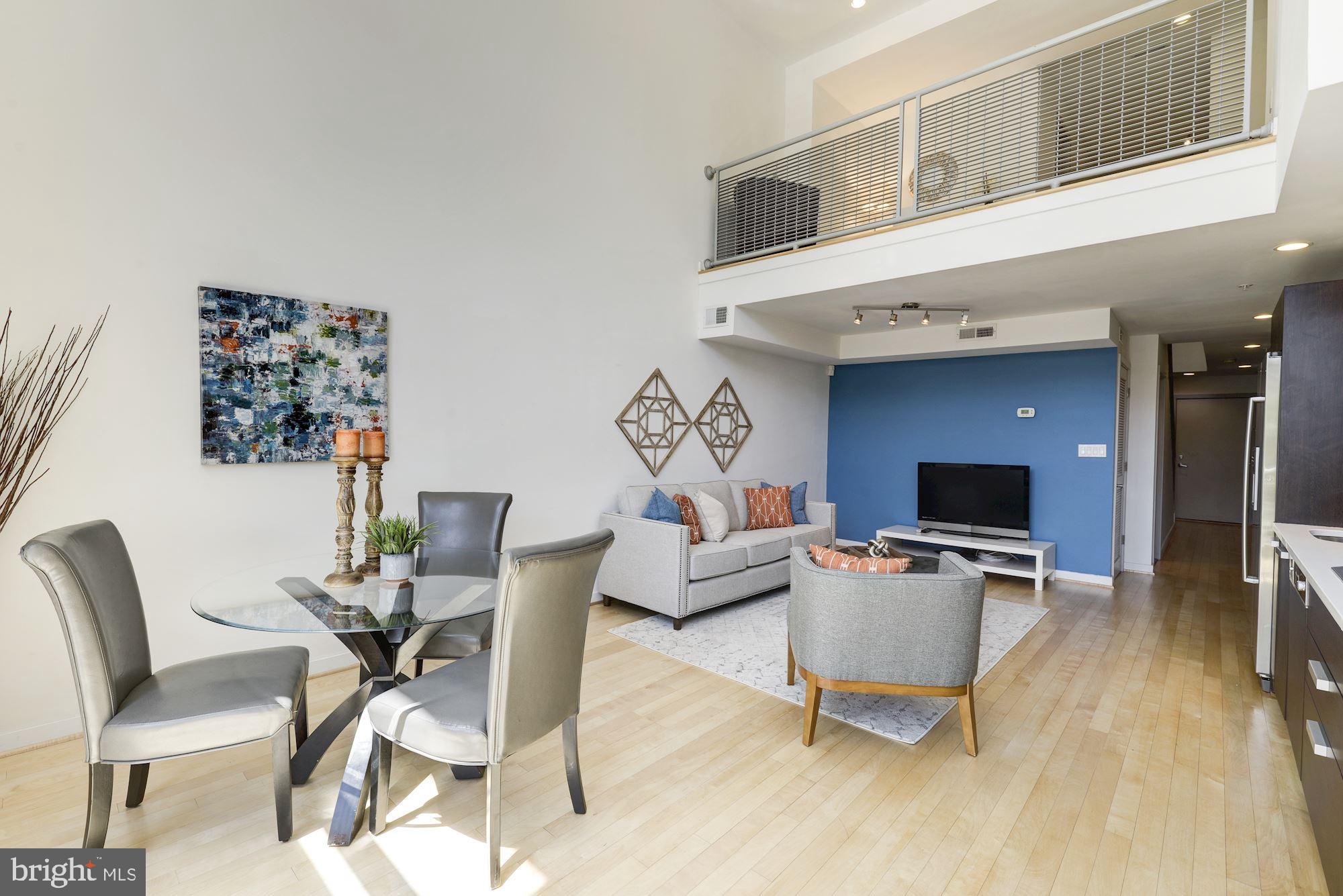 1466 Harvard Street Northwest, Unit A2 Washington, DC 20009 - Photo 3 of 21 a living room with furniture a flat screen tv and wooden floor
