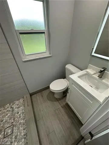 a bathroom with a sink toilet and a mirror