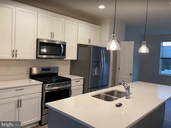 a kitchen with kitchen island a sink appliances and cabinets