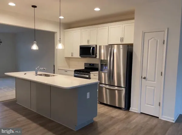 a kitchen with kitchen island a sink stainless steel appliances and cabinets