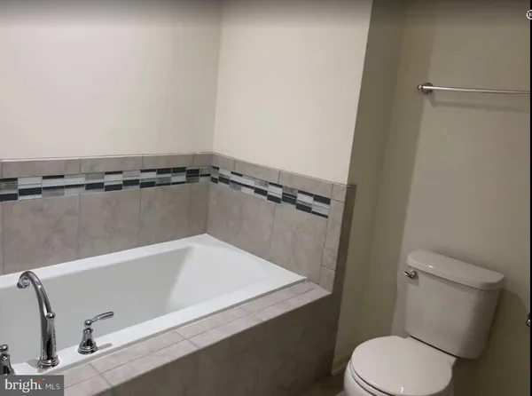 a bathroom with a toilet and a bath tub