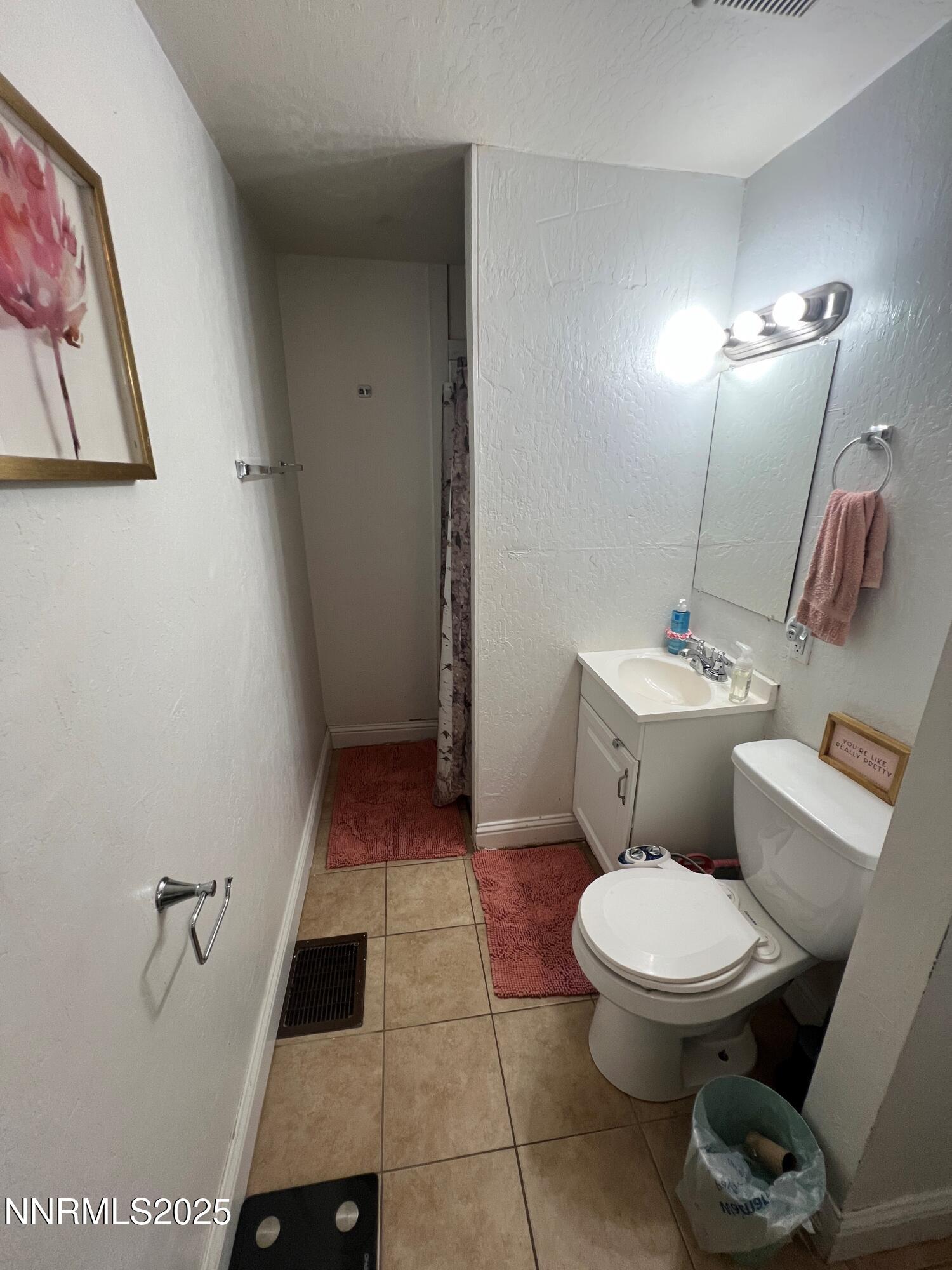 650 Elko Avenue Reno, NV 89512 - Photo 23 of 27 a white toilet sitting next to a bathroom sink and vanity