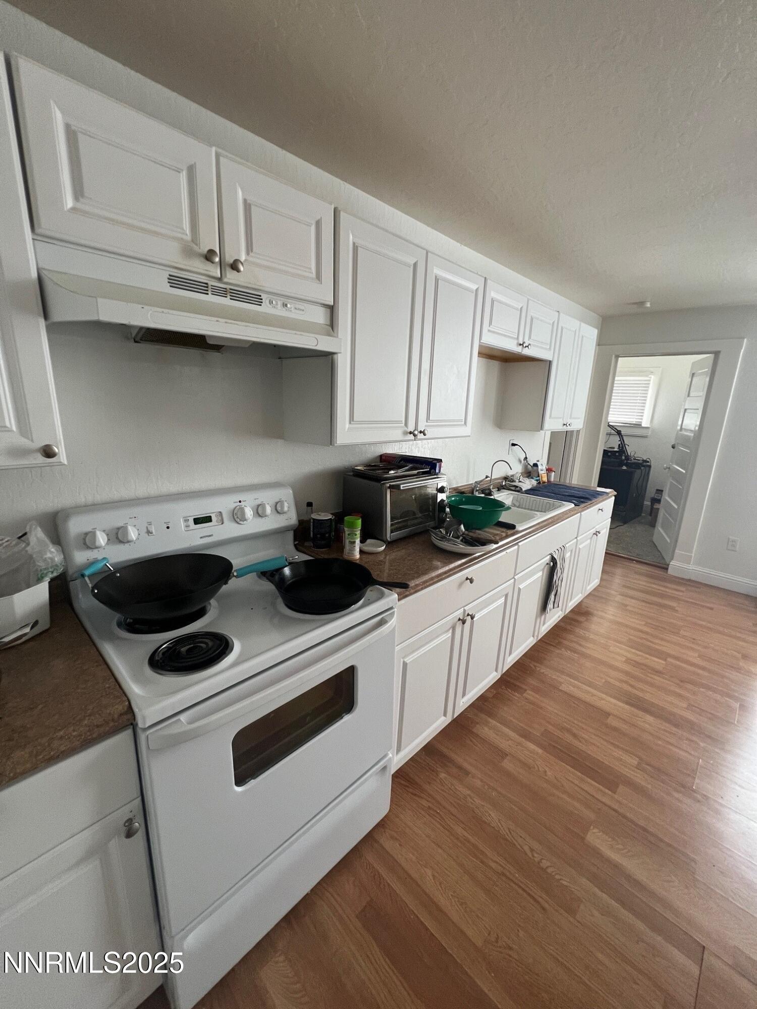 650 Elko Avenue Reno, NV 89512 - Photo 3 of 27 a kitchen with granite countertop white cabinets and white appliances