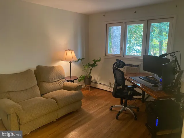 a livingroom with workspace and a couch