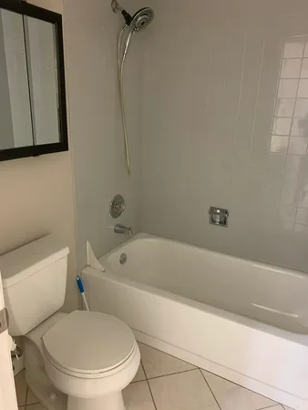 a white toilet sitting next to a bath tub