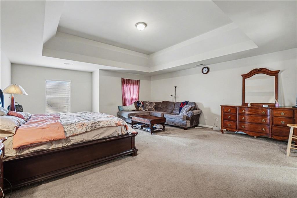4157 Sublime Trail Atlanta, GA 30349 - Photo 13 of 20 a spacious bedroom with a bed and a television