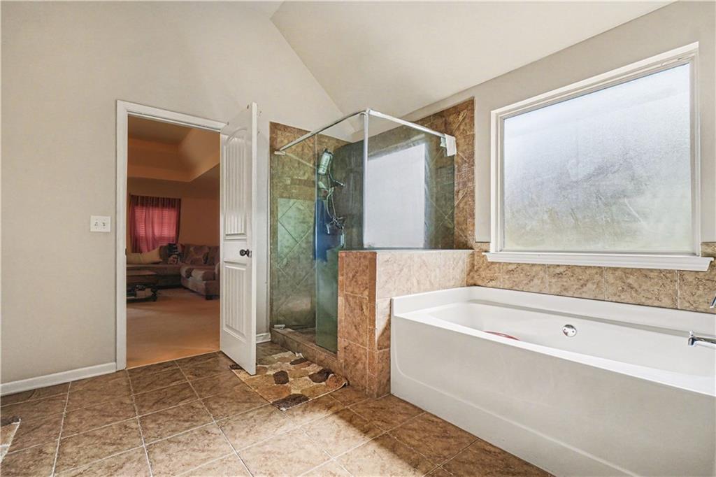 4157 Sublime Trail Atlanta, GA 30349 - Photo 15 of 20 a bathroom with a tub and a shower