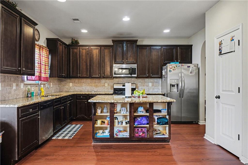 4157 Sublime Trail Atlanta, GA 30349 - Photo 8 of 20 a kitchen with stainless steel appliances granite countertop a refrigerator a stove top oven a sink and dishwasher with wooden floor