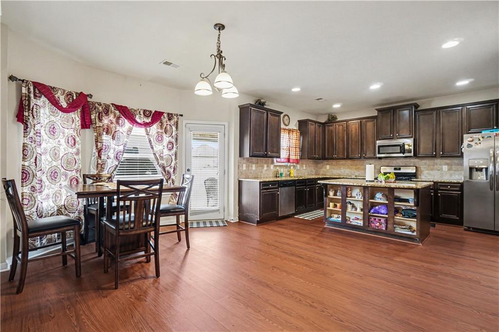 4157 Sublime Trail Atlanta, GA 30349 - Photo 9 of 20 a living room with stainless steel appliances kitchen island granite countertop furniture wooden floor and a kitchen view