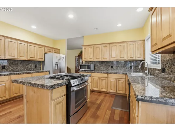 a kitchen with stainless steel appliances granite countertop a stove a sink and a granite counter tops