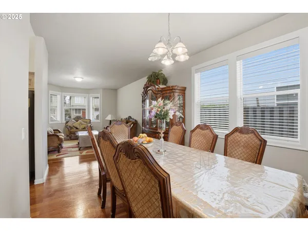 a view of a dining room with furniture a chandelier and a window