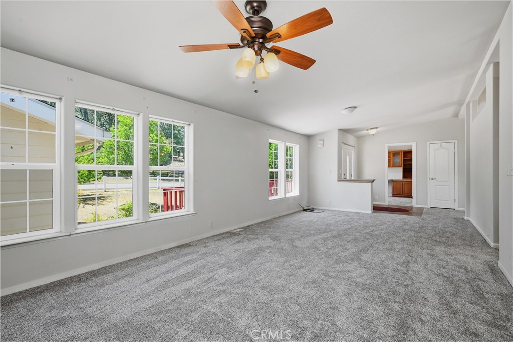 2860 Spring Valley Road Clearlake Oaks, CA 95423 - Photo 7 of 38 an empty room with windows and ceiling fan