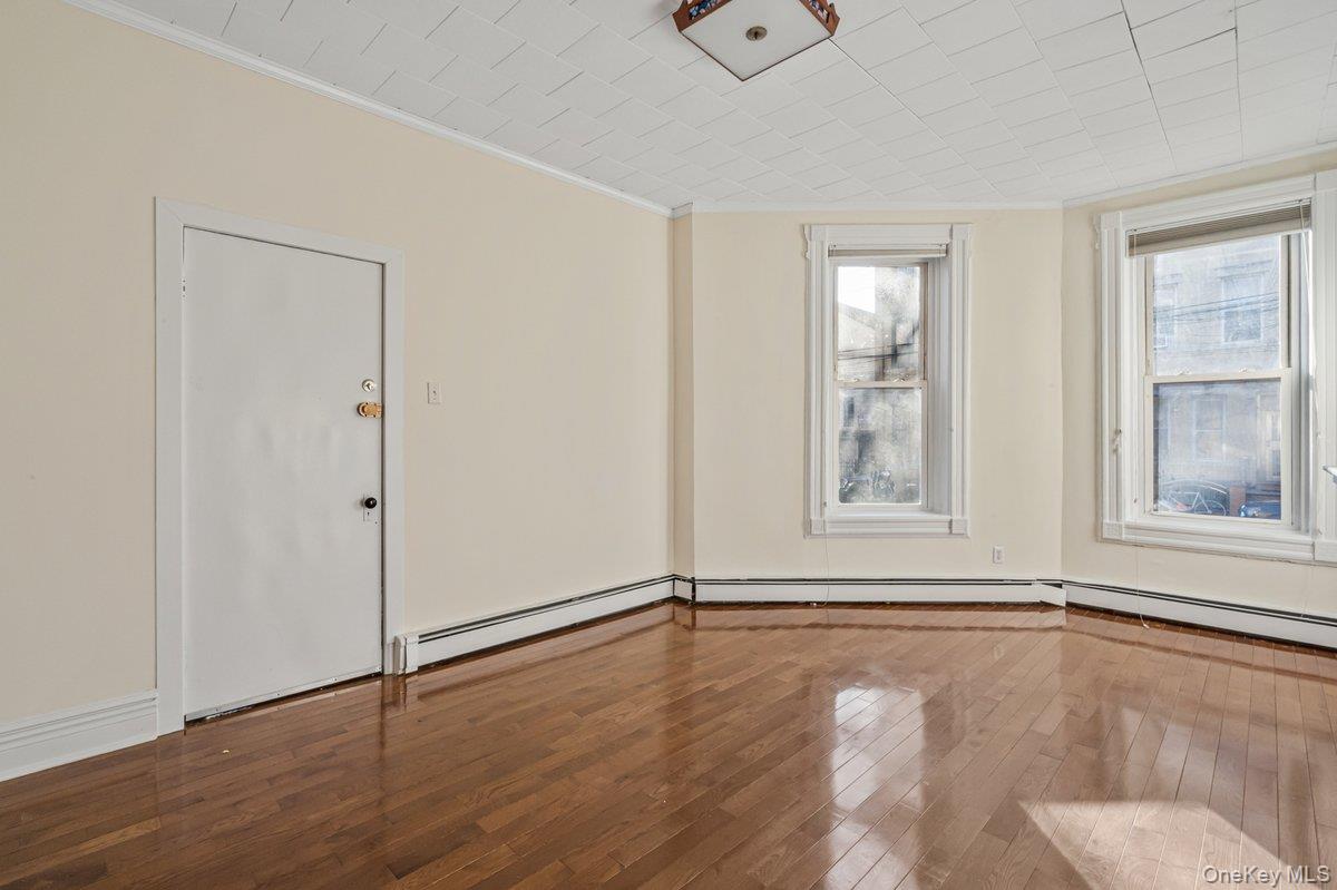 62 Sutton Street Brooklyn, NY 11222 - Photo 19 of 29 an empty room with wooden floor and windows