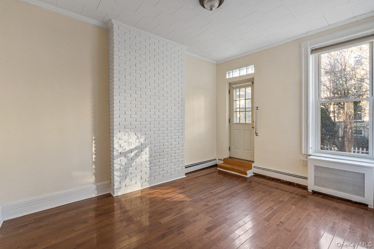 62 Sutton Street Brooklyn, NY 11222 - Photo 23 of 29 an empty room with wooden floor and windows