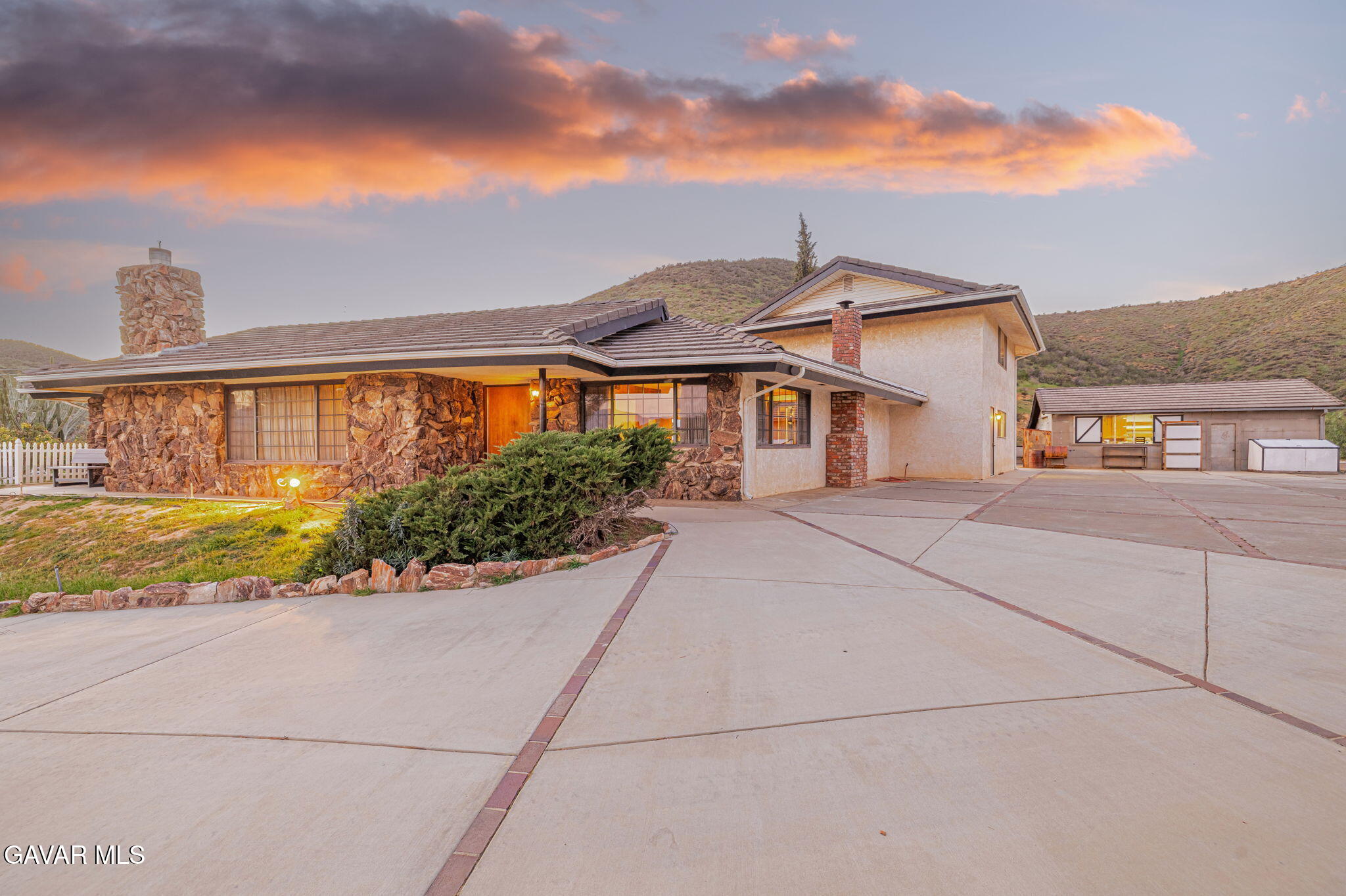 a front view of a house with a yard and potted plants