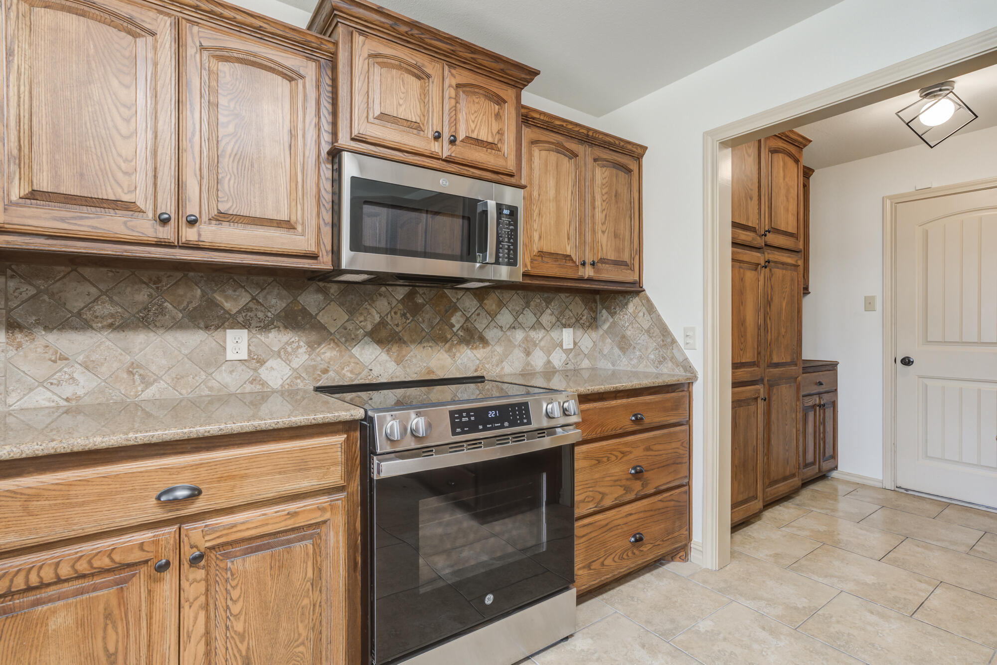 6509 72nd Street Lubbock, TX 79424 - Photo 11 of 40 a kitchen with granite countertop white cabinets stainless steel appliances and sink
