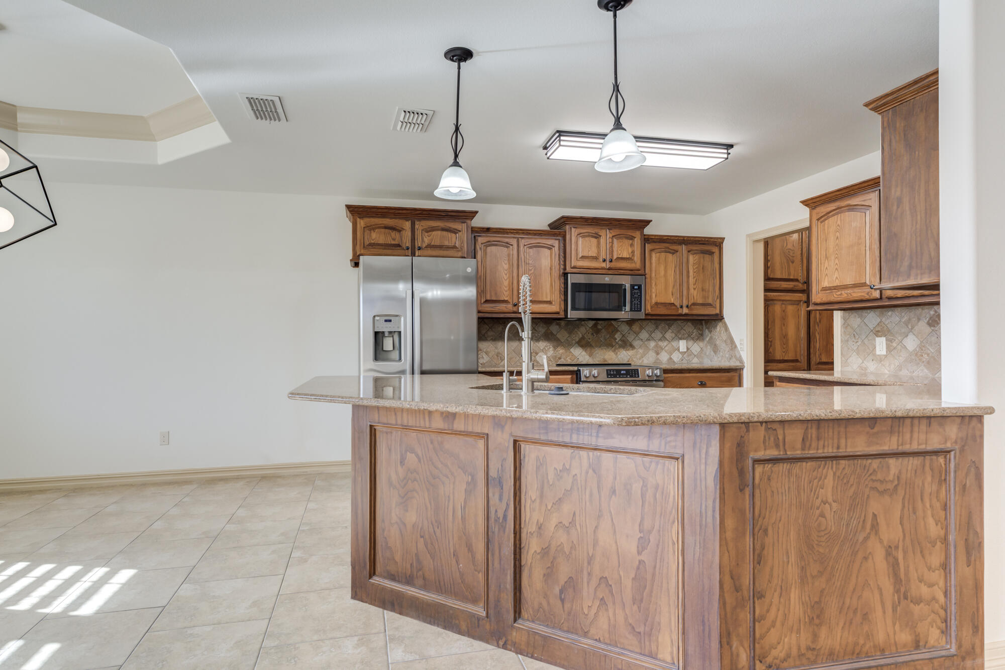 6509 72nd Street Lubbock, TX 79424 - Photo 15 of 40 a kitchen with stainless steel appliances granite countertop a sink and a refrigerator