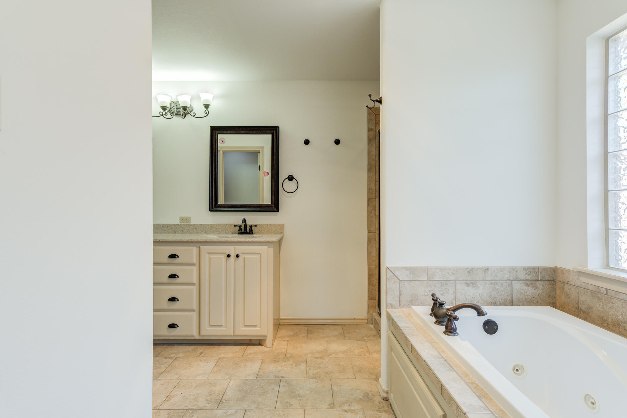 6509 72nd Street Lubbock, TX 79424 - Photo 20 of 40 a bathroom with a bathtub sink and mirror