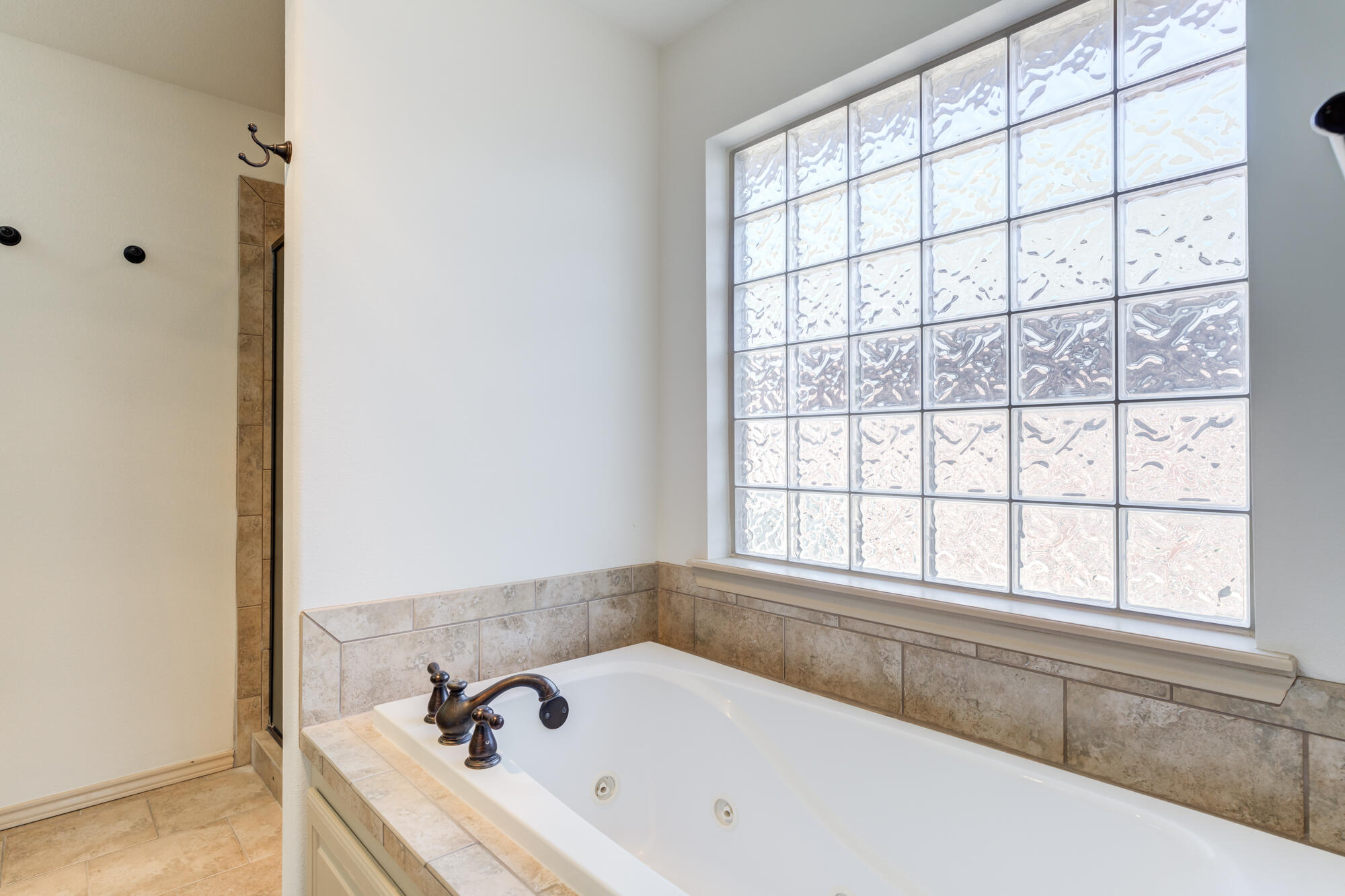 6509 72nd Street Lubbock, TX 79424 - Photo 21 of 40 a bathroom with a bathtub and next to a window