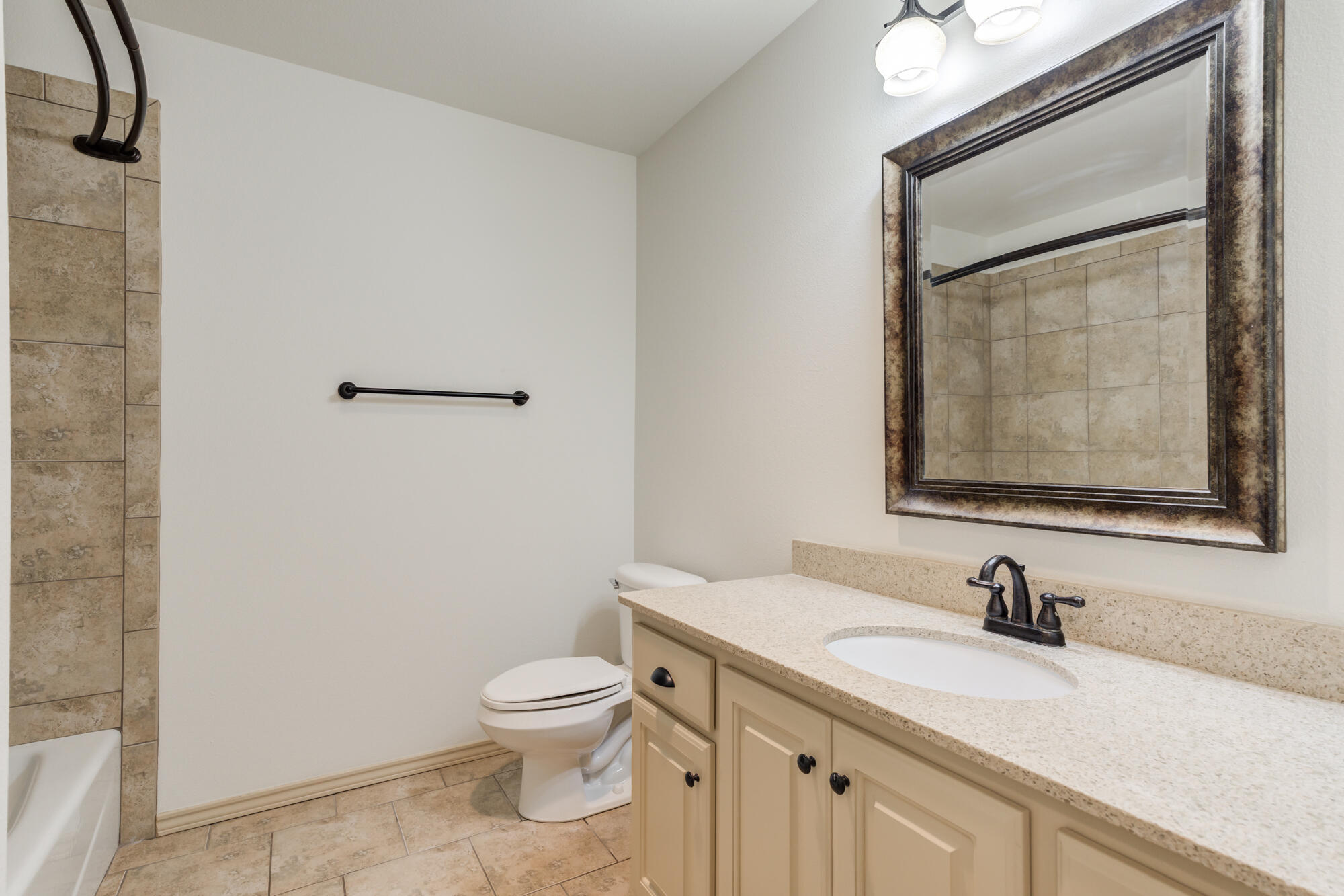 6509 72nd Street Lubbock, TX 79424 - Photo 32 of 40 a bathroom with a granite countertop sink mirror vanity and toilet
