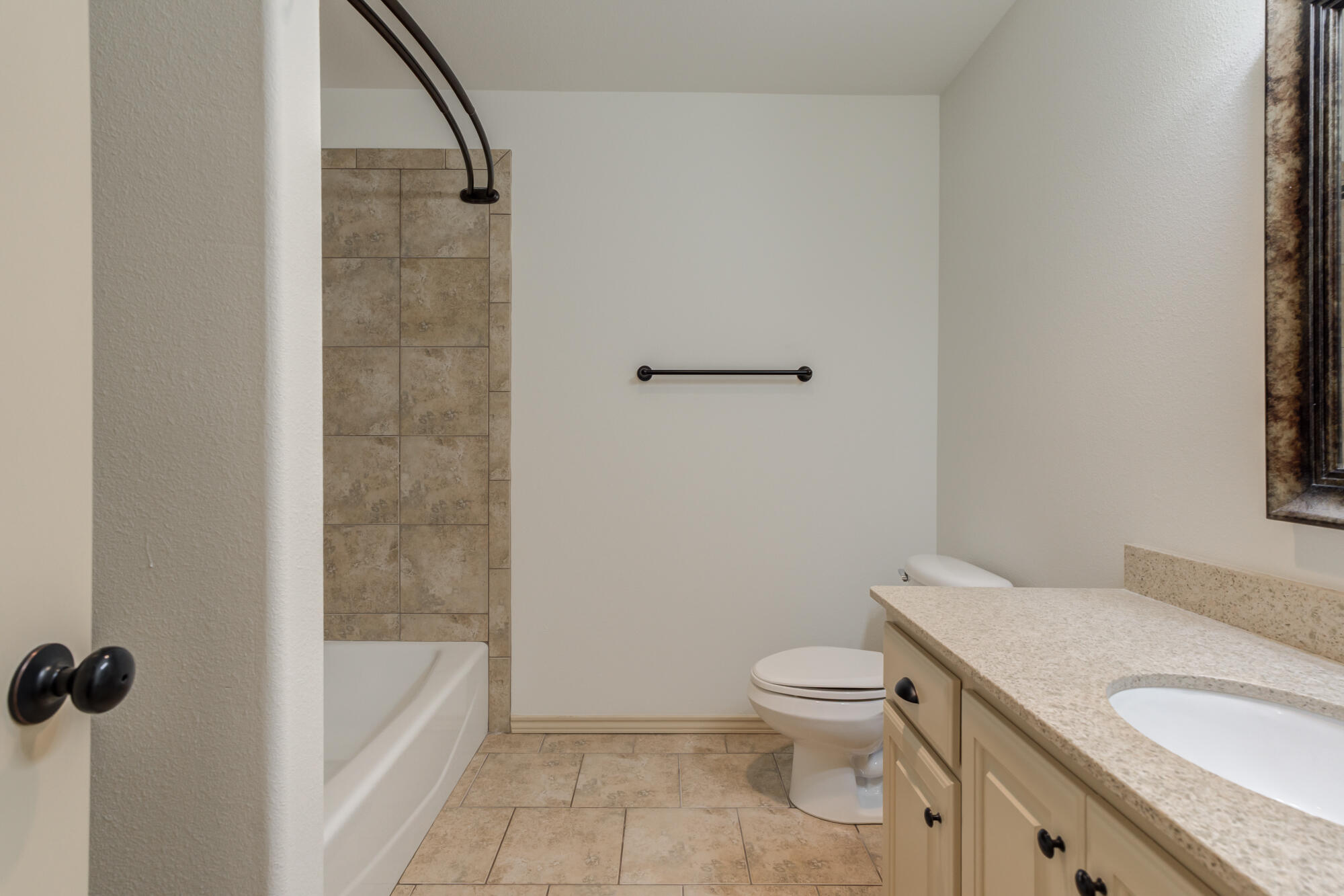 6509 72nd Street Lubbock, TX 79424 - Photo 33 of 40 a bathroom with a granite countertop toilet a sink and bathtub