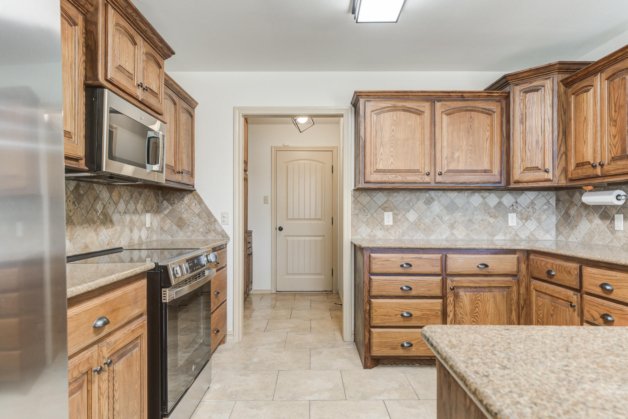 6509 72nd Street Lubbock, TX 79424 - Photo 9 of 40 a kitchen with stainless steel appliances granite countertop a stove and a sink