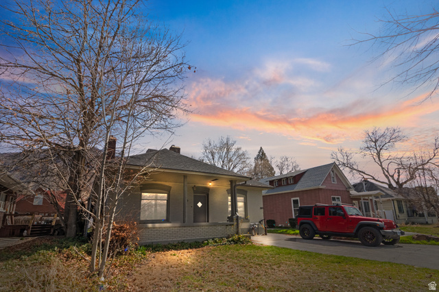 386 North 500 East Provo, UT 84606 - Photo 23 of 24 View of front of house with brick siding, a yard, a chimney, and a porch