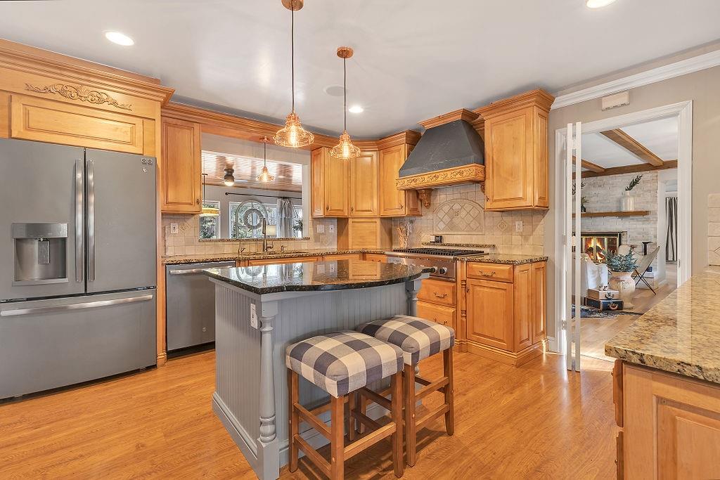 2 Davidson Drive Beaver Falls, PA 15010 - Photo 9 of 25 a kitchen with stainless steel appliances granite countertop a refrigerator a sink dishwasher a dining table and chairs with wooden floor