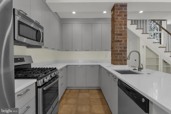 a kitchen with stainless steel appliances a stove microwave and sink