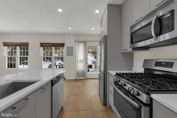 a kitchen with stainless steel appliances granite countertop a sink and a stove