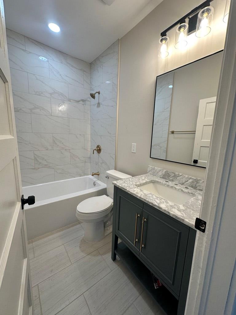 1432 22nd Street Columbus, GA 31901 - Photo 17 of 18 a bathroom with a granite countertop sink a toilet and shower