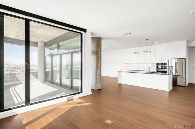 a view of kitchen with refrigerator and wooden floor