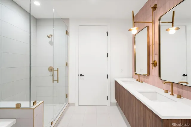 a bathroom with a double vanity sink mirror and shower