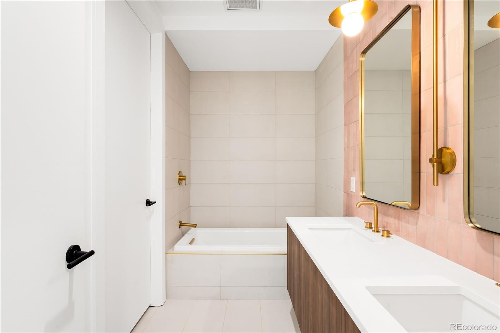 3520 Chestnut Place, Unit 1101 Denver, CO 80216 - Photo 32 of 44 a bathroom with a tub sink and mirror