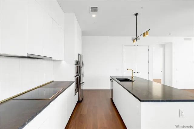 a kitchen with stainless steel appliances granite countertop a sink and a refrigerator