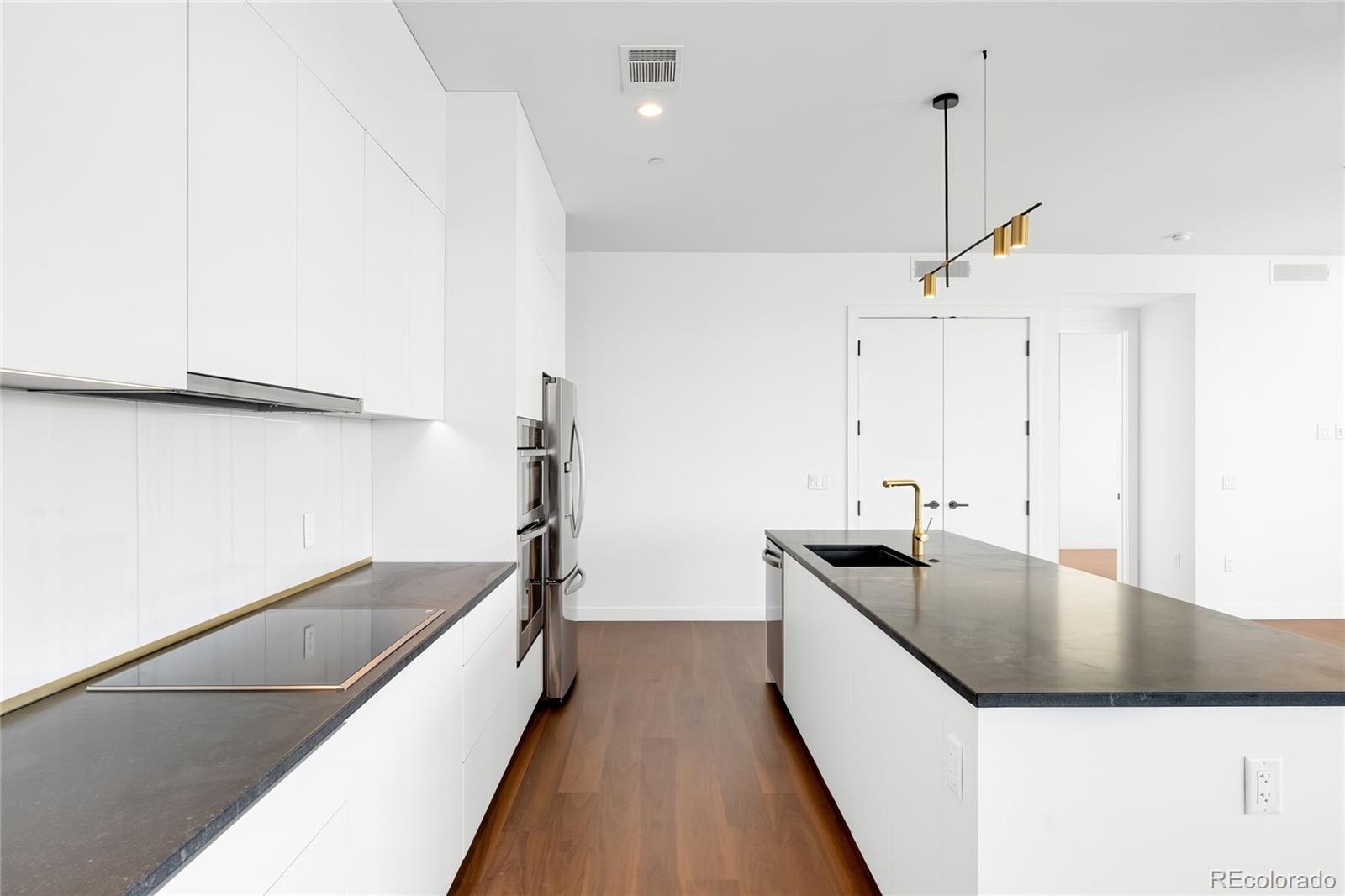 3520 Chestnut Place, Unit 1101 Denver, CO 80216 - Photo 6 of 44 a kitchen with stainless steel appliances granite countertop a sink and a refrigerator