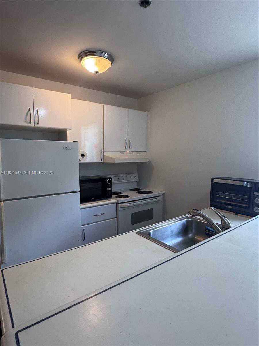 361 Collins Avenue, Unit A2 Miami Beach, FL 33139 - Photo 11 of 25 a kitchen that has a sink and a stove