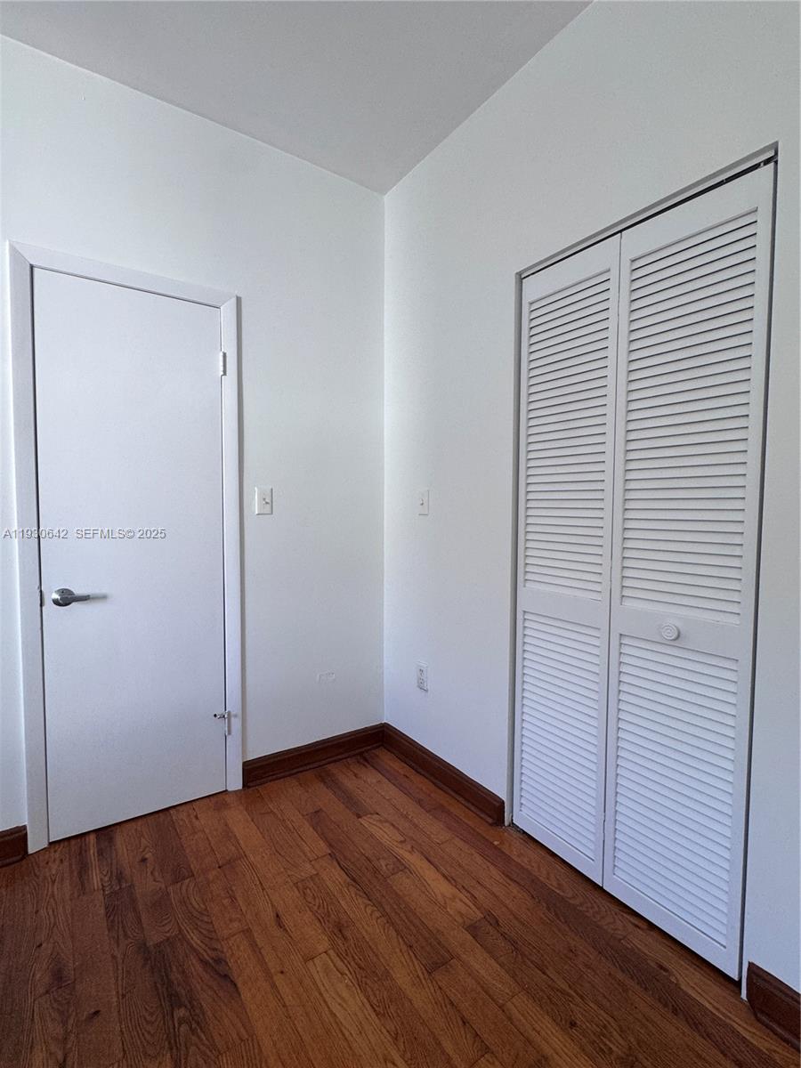 361 Collins Avenue, Unit A2 Miami Beach, FL 33139 - Photo 13 of 25 an empty room with wooden floor